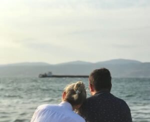 A couple sitting by the sea in İzmir, Türkiye, enjoying a serene vacation moment.